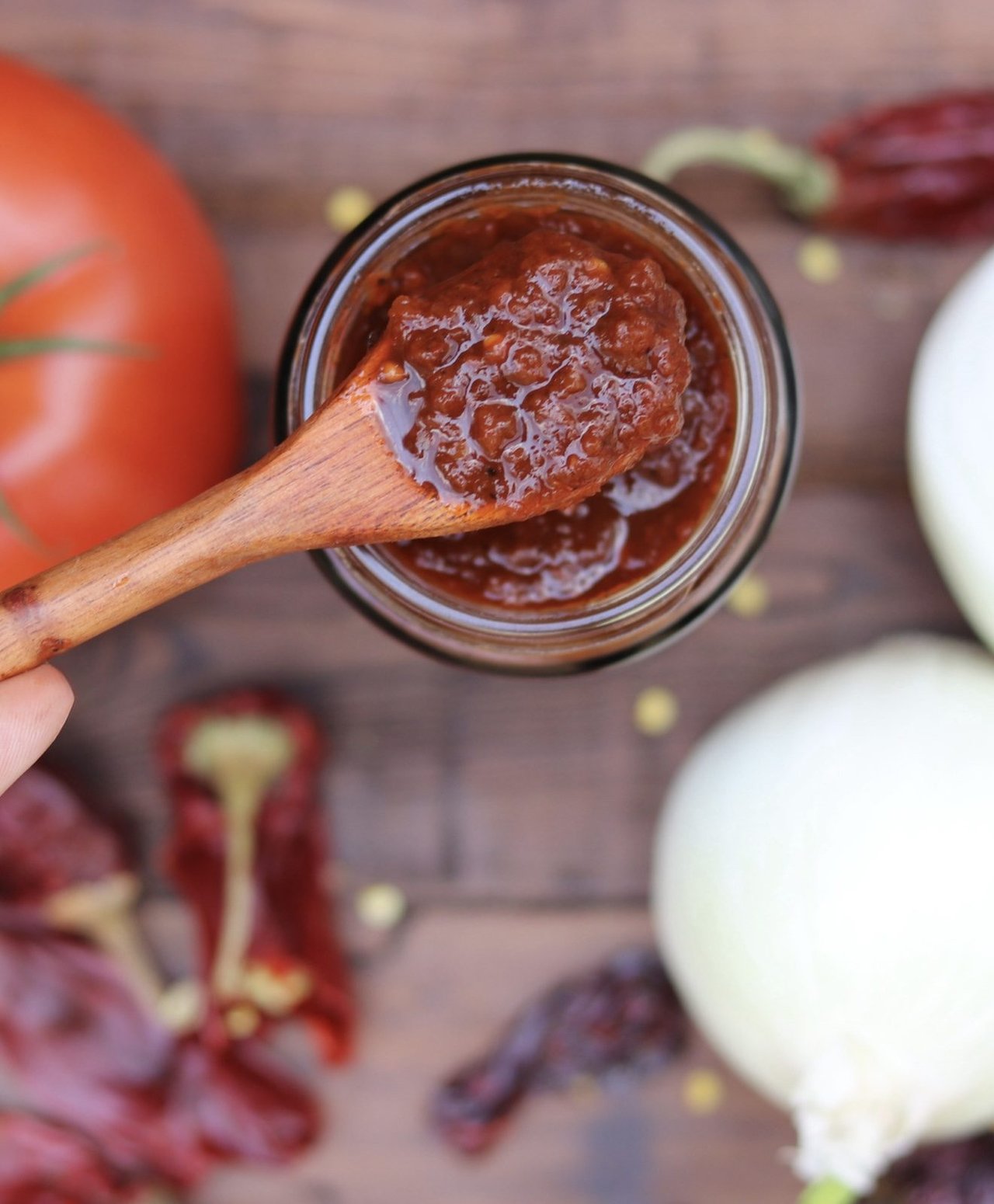 Salsa roja en un frasco con cuchara de madera