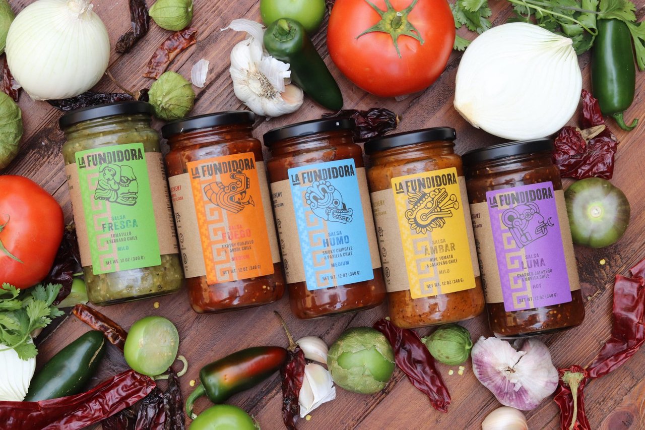 Las cinco salsas La Fundidora entre jitomates, cebollas, ajos y chiles